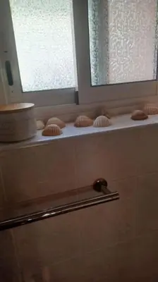 a bathroom with a window and a shelf with cupcakes at Vue de rêve sur lagune de mer in Bages