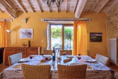 a dining room with a table with chairs and a window at Villa Fraisse by Villa Plus in Fraissé-des-Corbières