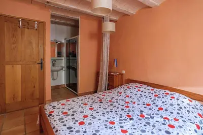 a bedroom with a bed with red flowers on it at Villa Fraisse by Villa Plus in Fraissé-des-Corbières