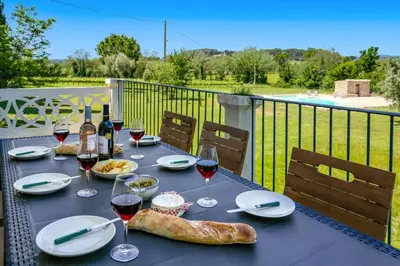 a table with glasses of wine and a bagel on it at Villa Domaine du Midi by Villa Plus in Capestang