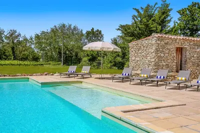 a swimming pool with lounge chairs and an umbrella at Villa Domaine du Midi by Villa Plus in Capestang