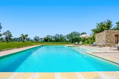 a swimming pool with blue water in a yard at Villa Domaine du Midi by Villa Plus in Capestang