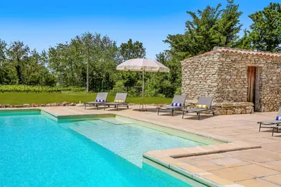 a swimming pool with lounge chairs and an umbrella at Villa Domaine du Midi by Villa Plus in Capestang