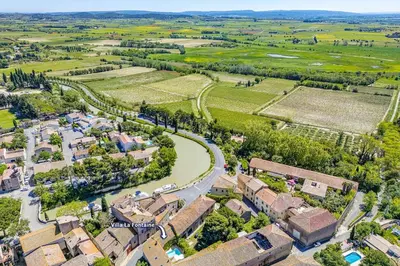 an aerial view of a village with a river at Villa La Fontaine by Villa Plus in Capestang