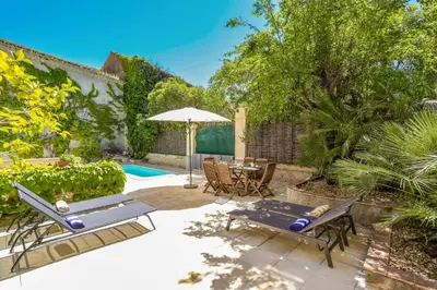 a patio with a table and chairs and an umbrella at Villa La Fontaine by Villa Plus in Capestang