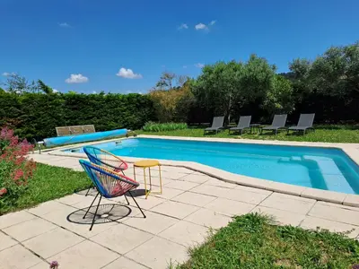 a swimming pool with chairs and a table next to it at Logement - Carcassonne in Carcassonne