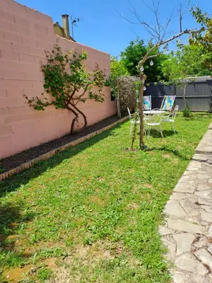 a garden with a table and chairs next to a wall at Logement - Carcassonne in Carcassonne