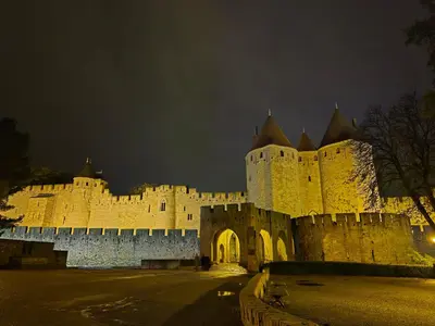 a large castle at night with its lights on at Logement - Carcassonne in Carcassonne
