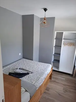 a bedroom with a bed and a refrigerator at Logement - Carcassonne in Carcassonne