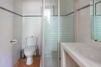 a white bathroom with a toilet and a sink at Villa Domaine Saint Roch by Villa Plus in Gaja-et-Villedieu