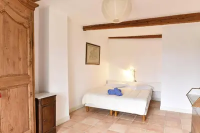 a bedroom with a bed with a blue pillow on it at Villa Domaine Saint Roch by Villa Plus in Gaja-et-Villedieu