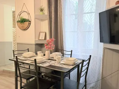 a dining room table with chairs and a television at La Bastide in Carcassonne