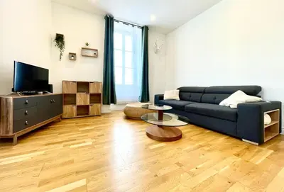 a living room with a blue couch and a tv at Chez Pierrot - Pont-Neuf - Vue Cité Médiévale in Carcassonne