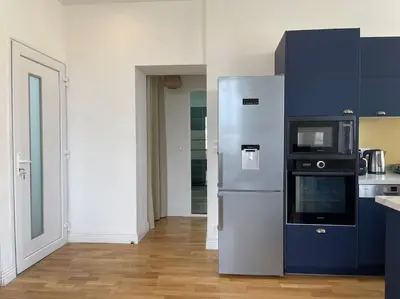 a kitchen with a refrigerator and a microwave at Chez Pierrot - Pont-Neuf - Vue Cité Médiévale in Carcassonne