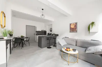 a living room with a couch and a table at Appartement central confortable et spacieux in Carcassonne