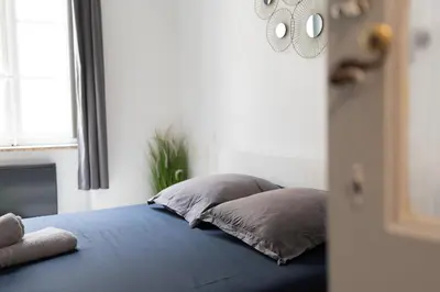 a bed with two pillows on it in a room at Appartement central confortable et spacieux in Carcassonne