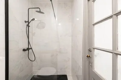 a shower with a glass door in a bathroom at Appartement central confortable et spacieux in Carcassonne