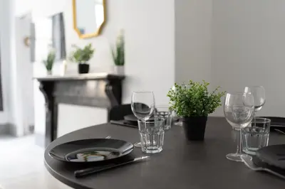 a wooden table with glasses and a plate on it at Appartement central confortable et spacieux in Carcassonne