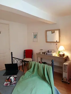 a room with a bed and a desk with a mirror at 5bis in Quillan