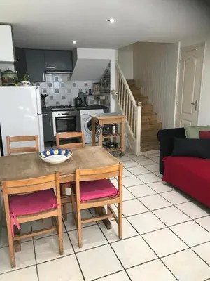 a kitchen and a living room with a table and chairs at 5bis in Quillan