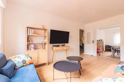 a living room with a blue couch and a tv at La Douce Occitane - Maison climatisée pour 6 in Carcassonne