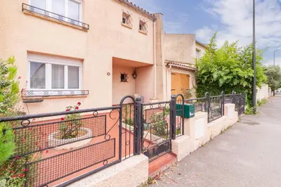 a house with a black fence in front of it at La Douce Occitane - Maison climatisée pour 6 in Carcassonne