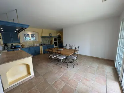 a kitchen and dining room with a table and chairs at Villa Les amandiers avec piscine in Saint-Laurent-de-la-Cabrerisse