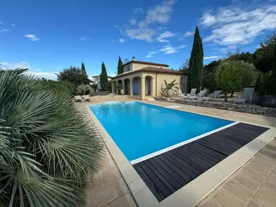 a swimming pool in front of a house at Villa Les amandiers avec piscine in Saint-Laurent-de-la-Cabrerisse