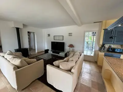 a living room with two couches and a flat screen tv at Villa Les amandiers avec piscine in Saint-Laurent-de-la-Cabrerisse