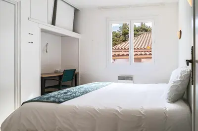 a white bedroom with a bed and a window at Villa Terra Mera piscine privée proche de Narbonne in Cuxac-dʼAude