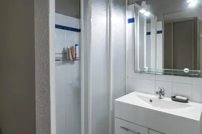 a white bathroom with a sink and a mirror at Villa Terra Mera piscine privée proche de Narbonne in Cuxac-dʼAude