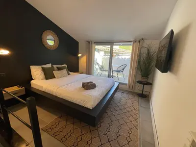 a bedroom with a bed with a mirror and a window at La Tuilerie du Bazalac in Trèbes