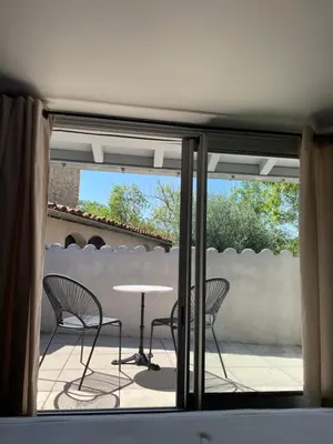a patio with a table and chairs on a balcony at La Tuilerie du Bazalac in Trèbes