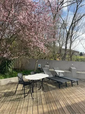 a picnic table and two chairs on a wooden deck at La Tuilerie du Bazalac in Trèbes