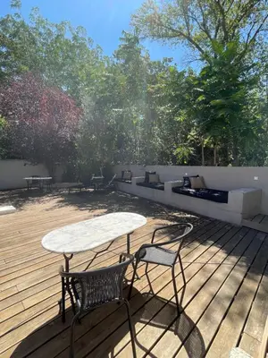 a patio with a table and chairs on a deck at La Tuilerie du Bazalac in Trèbes