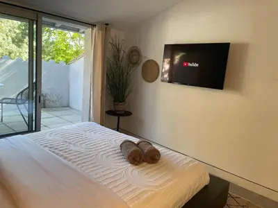 a bedroom with a bed with a flat screen tv on the wall at La Tuilerie du Bazalac in Trèbes