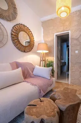 a living room with a couch and a table and a mirror at Évasion scandinave à Narbonne élégance et confort réunis ! in Narbonne