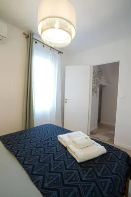 a bedroom with a bed with two white towels on it at Évasion scandinave à Narbonne élégance et confort réunis ! in Narbonne