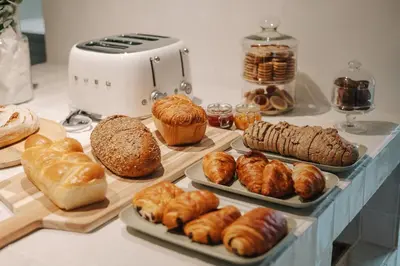a table with different types of bread and pastries at La Demeure de la Cité by Jean Bacou in Carcassonne