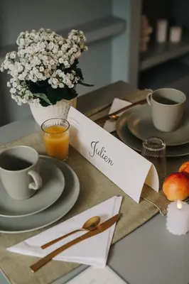 a table with plates and cups of coffee and flowers at La Demeure de la Cité by Jean Bacou in Carcassonne