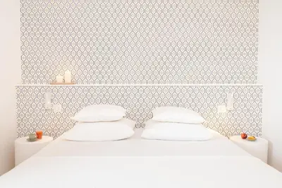 a bedroom with a white bed with white pillows at La Demeure de la Cité by Jean Bacou in Carcassonne