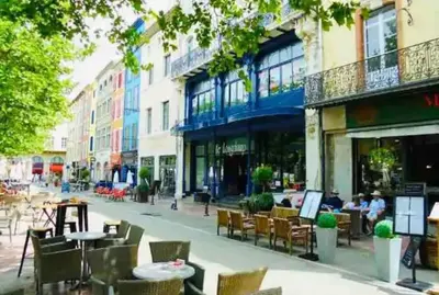 a city street with tables and chairs and buildings at Appartement T2 avec vue château in Carcassone