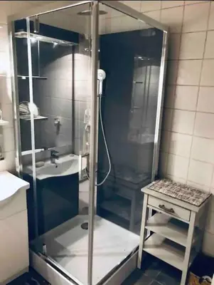 a shower stall in a bathroom with a sink at Appartement T2 avec vue château in Carcassone