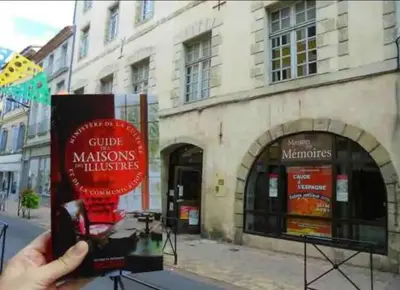a person holding up a sign in front of a building at Appartement T2 avec vue château in Carcassone