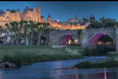 a bridge over a river with a castle in the background at Appartement T2 avec vue château in Carcassone