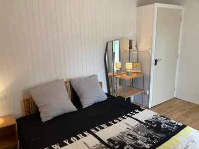 a bedroom with a bed with two pillows and a mirror at Maison NATURALY in Laprade