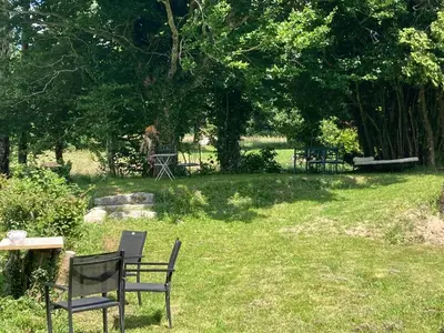 a park with a bench and a table in the grass at Maison NATURALY in Laprade