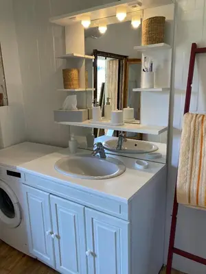 a bathroom with a sink and a washing machine at Maison NATURALY in Laprade