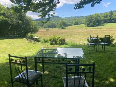a group of tables and chairs in a field at Maison NATURALY in Laprade