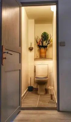 a bathroom with a toilet with a vase of flowers at La maison des Chevaliers in Campagne-sur-Aude